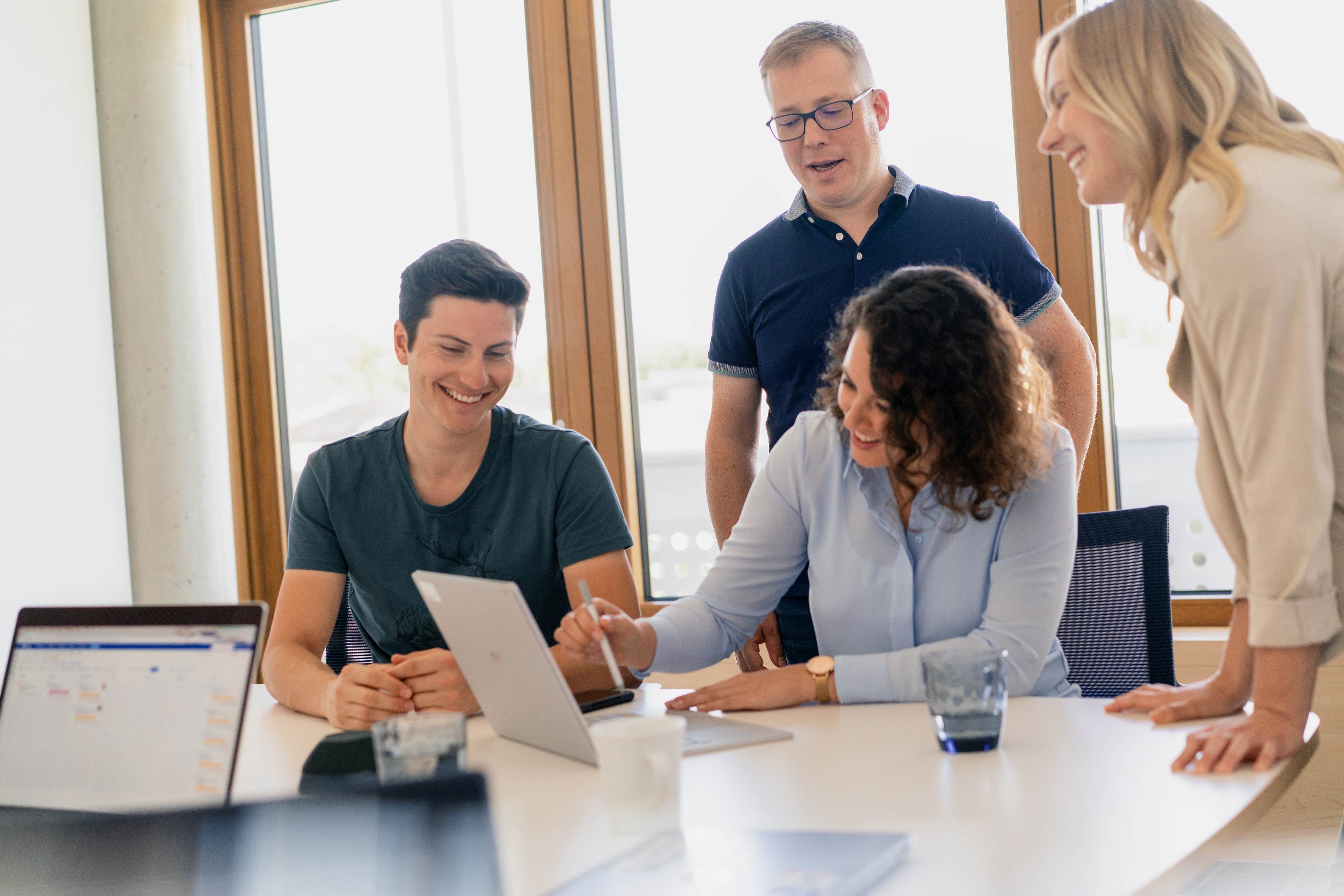 Vier IT-Expertinnen und -Experten lachen gemeinsam