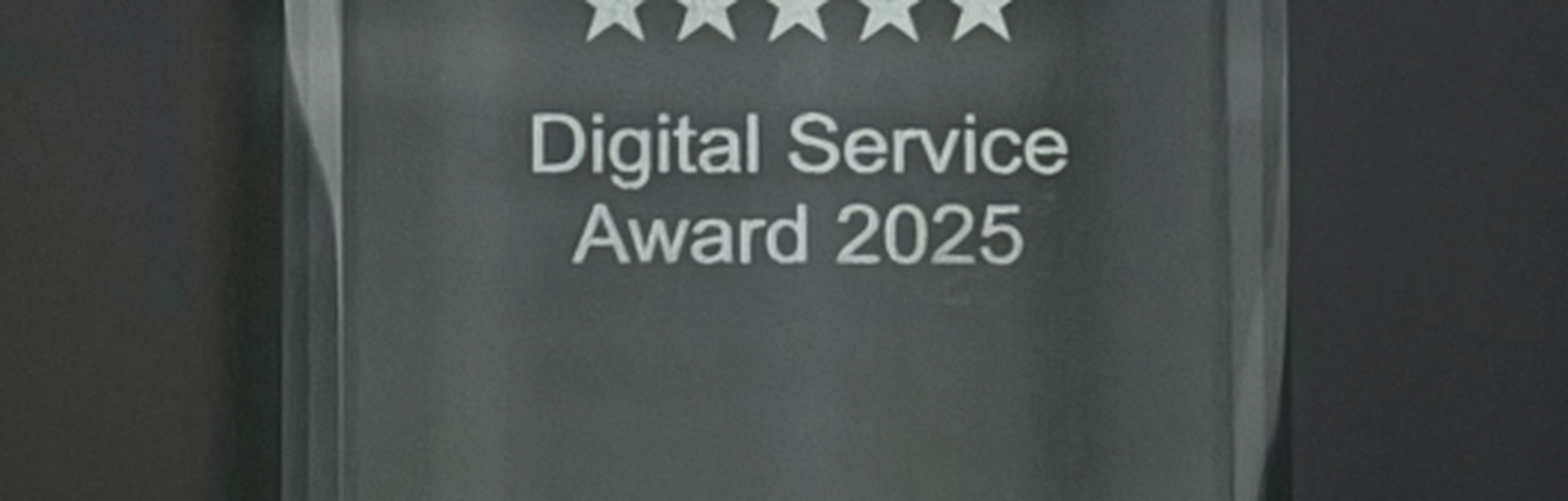 Glaspokal mit der Aufschrift 1. Platz Digital Service Award 2025 und darunter appinio KMPG Aivitex